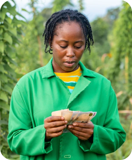 Farmer holding cash in a field