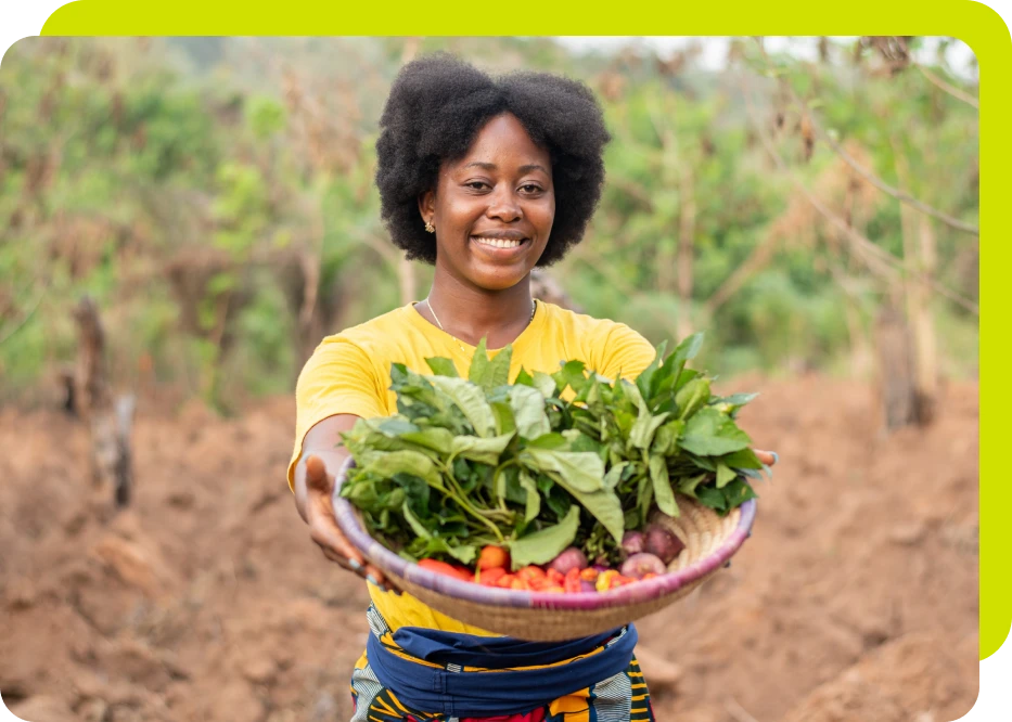 Smiling farmer holding a basket of fresh greens